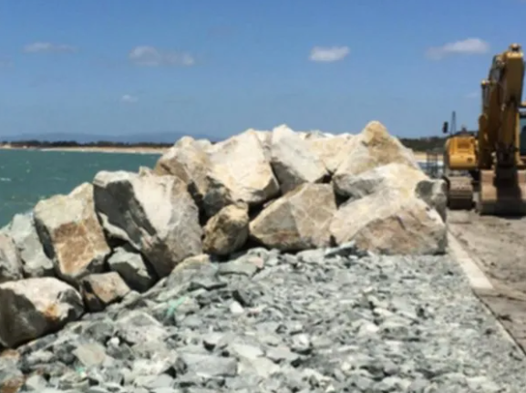 Rocky Seawall With an Excavator on a Sunny Day Near the Ocean — CJD Investments (NQ) Pty Ltd in Mackay Harbour, QLD