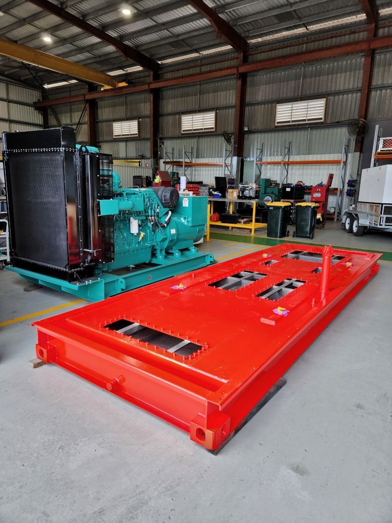 A Red Box Is Sitting In A Warehouse Next To A Green Generator — Great Energy in Port Douglas, QLD