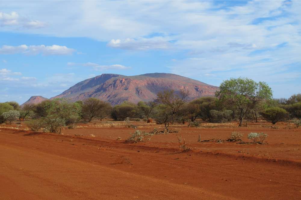 A Dirt Road In The Desert With A Mountain — Great Energy in Western Australia, QLD