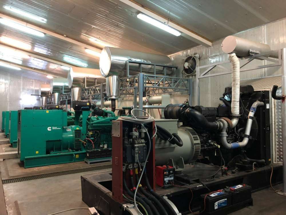 A Row Of Generators Are Sitting Inside Of A Building — Great Energy in Perth, QLD