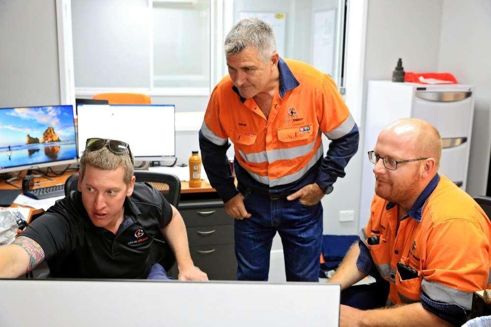 Three Men Are Looking At A Computer Screen In An Office — Great Energy in Portsmith, QLD