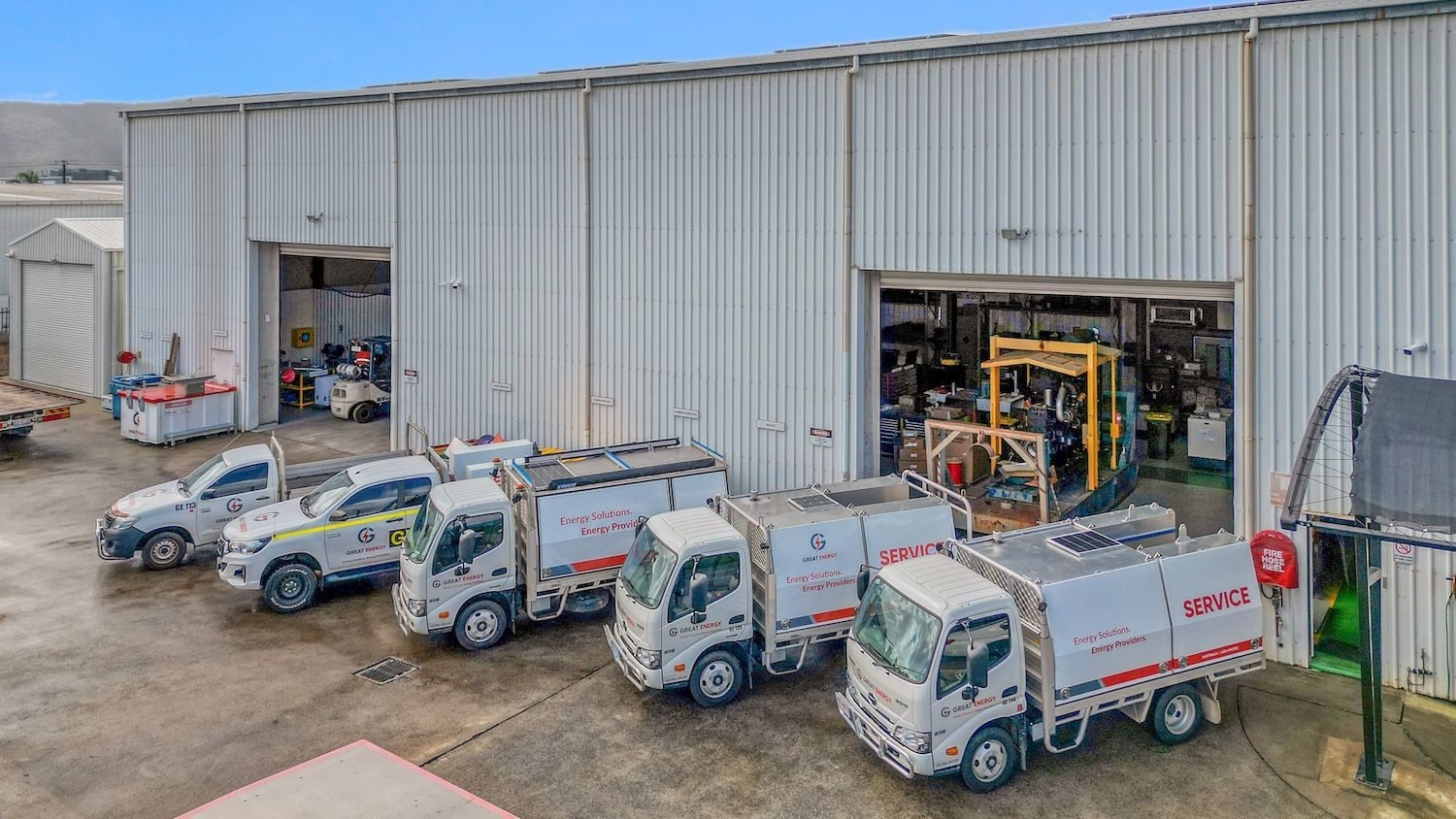 A Row Of Trucks Are Parked In Front Of A Building — Great Energy in Perth, QLD