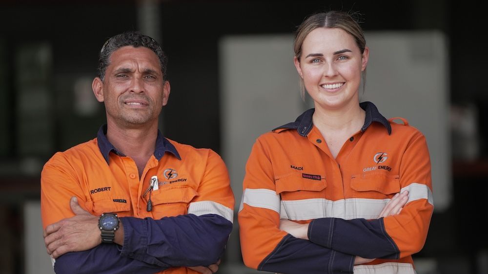 A Man And A Woman Are Standing Next To Each Other With Their Arms Crossed — Great Energy in Perth, QLD