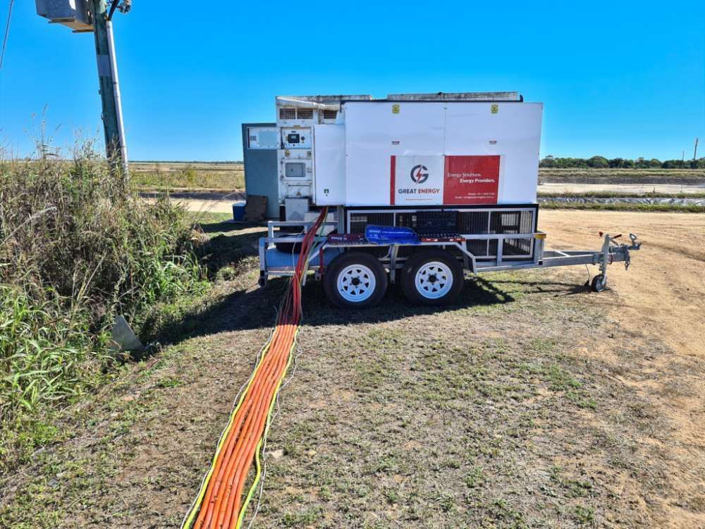 A Trailer With A Hose Attached To It Is Parked In A Field Next To A Power Pole — Great Energy in Portsmith, QLD