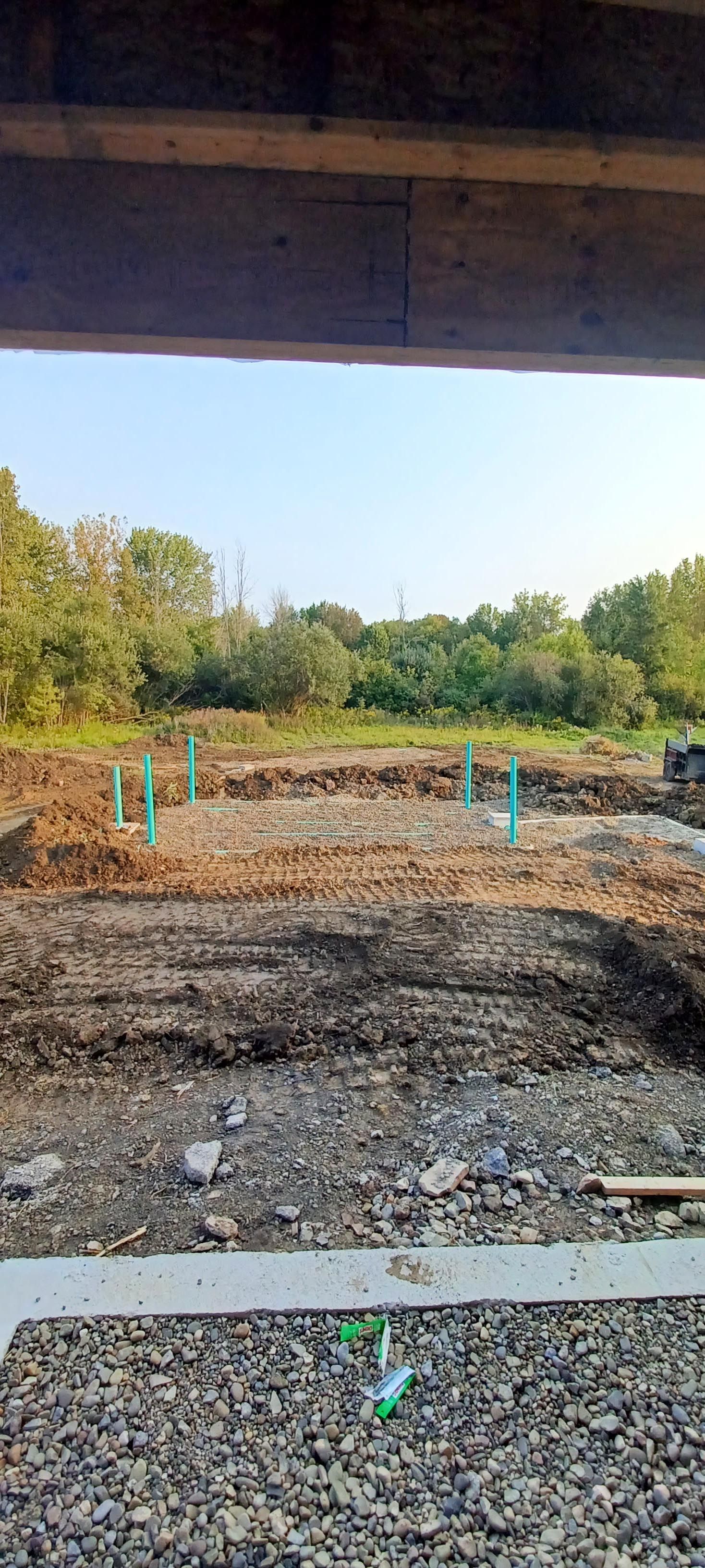 A view of a construction site from under a bridge.