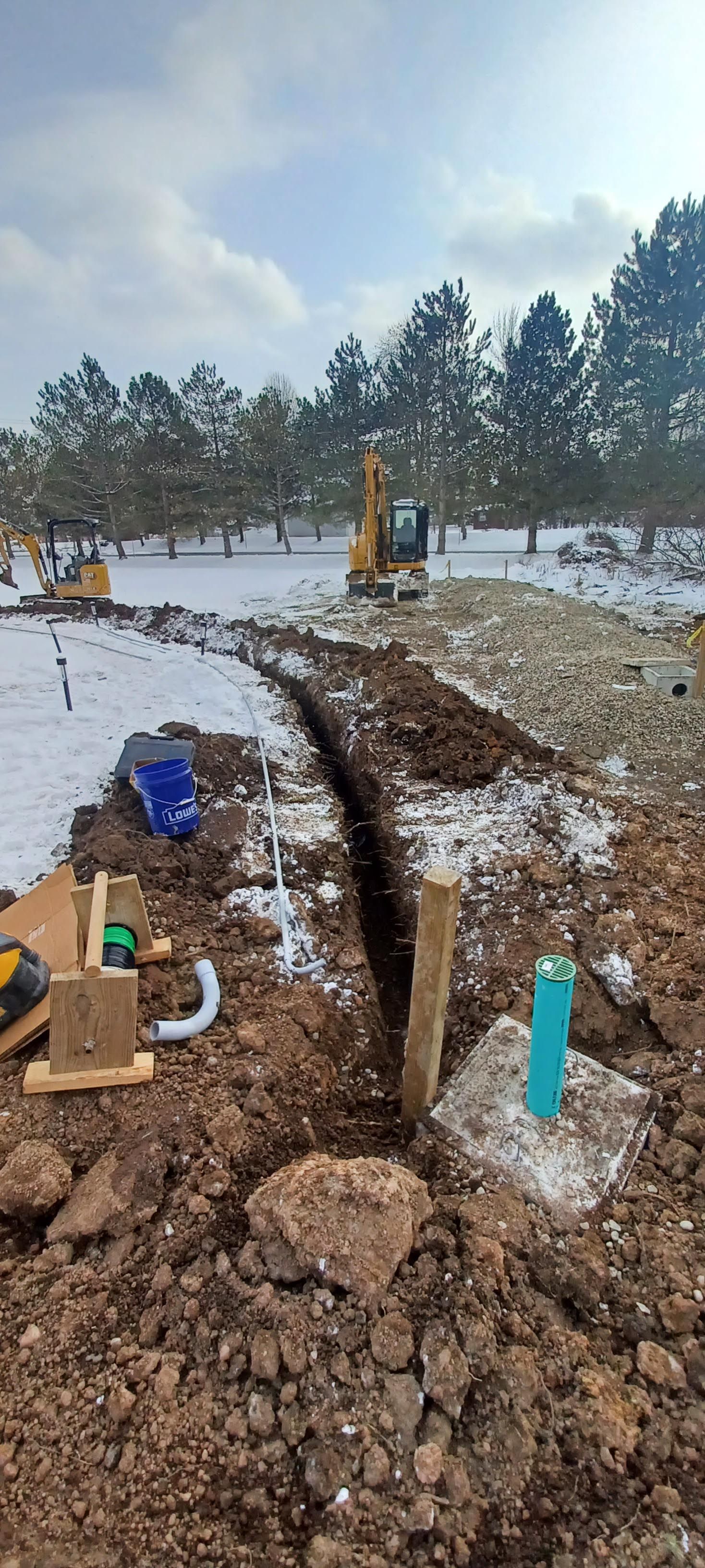 A construction site with a lot of dirt and trees in the background.