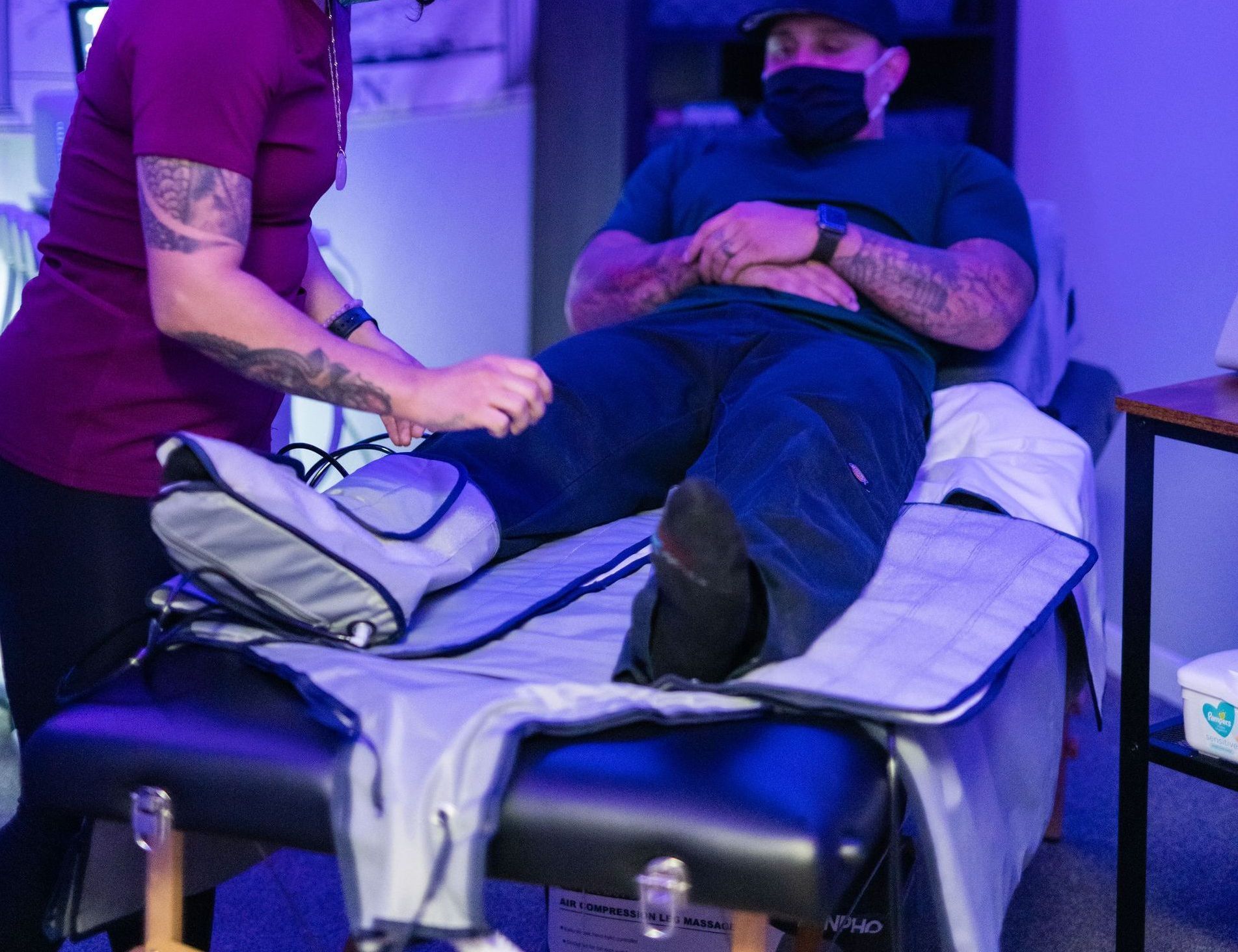 A man is laying on a bed getting a massage from a woman.