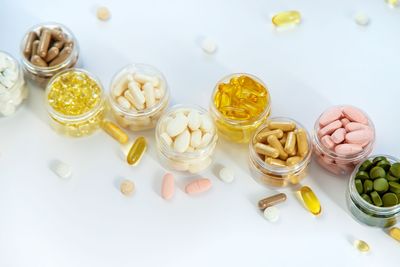 A row of jars filled with different types of vitamins and supplements.