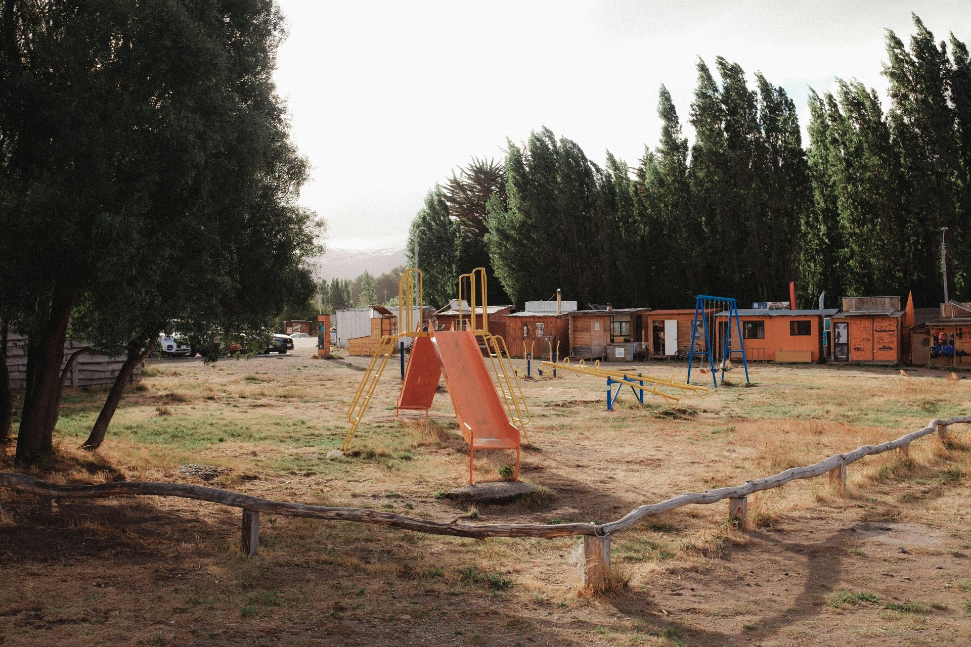 A playground with a slide in the middle of a field