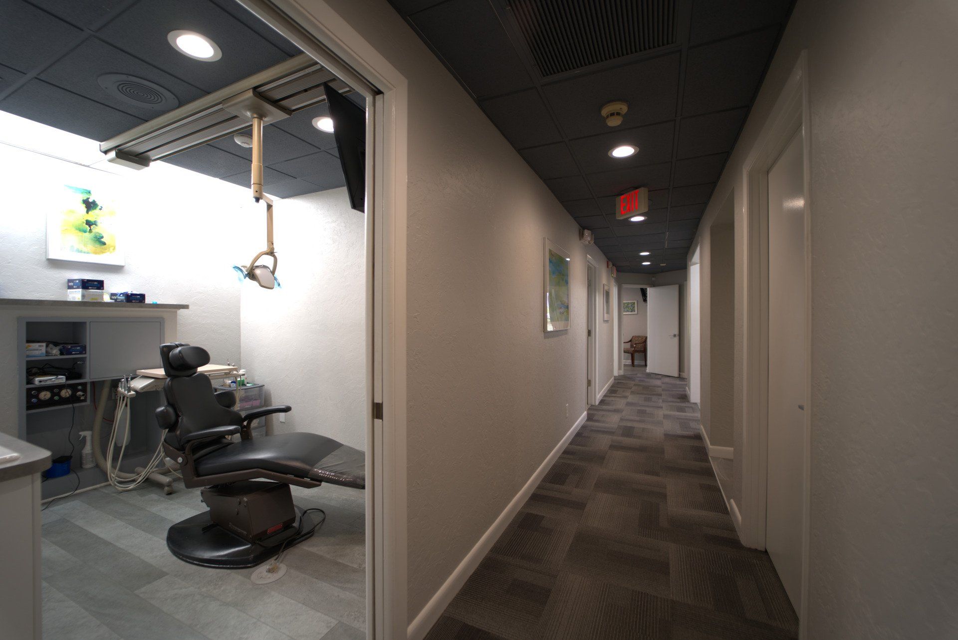 A dental office with a dental chair in the hallway