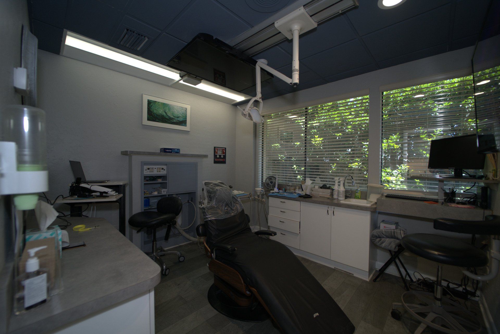 A dental office with a dental chair and a desk.