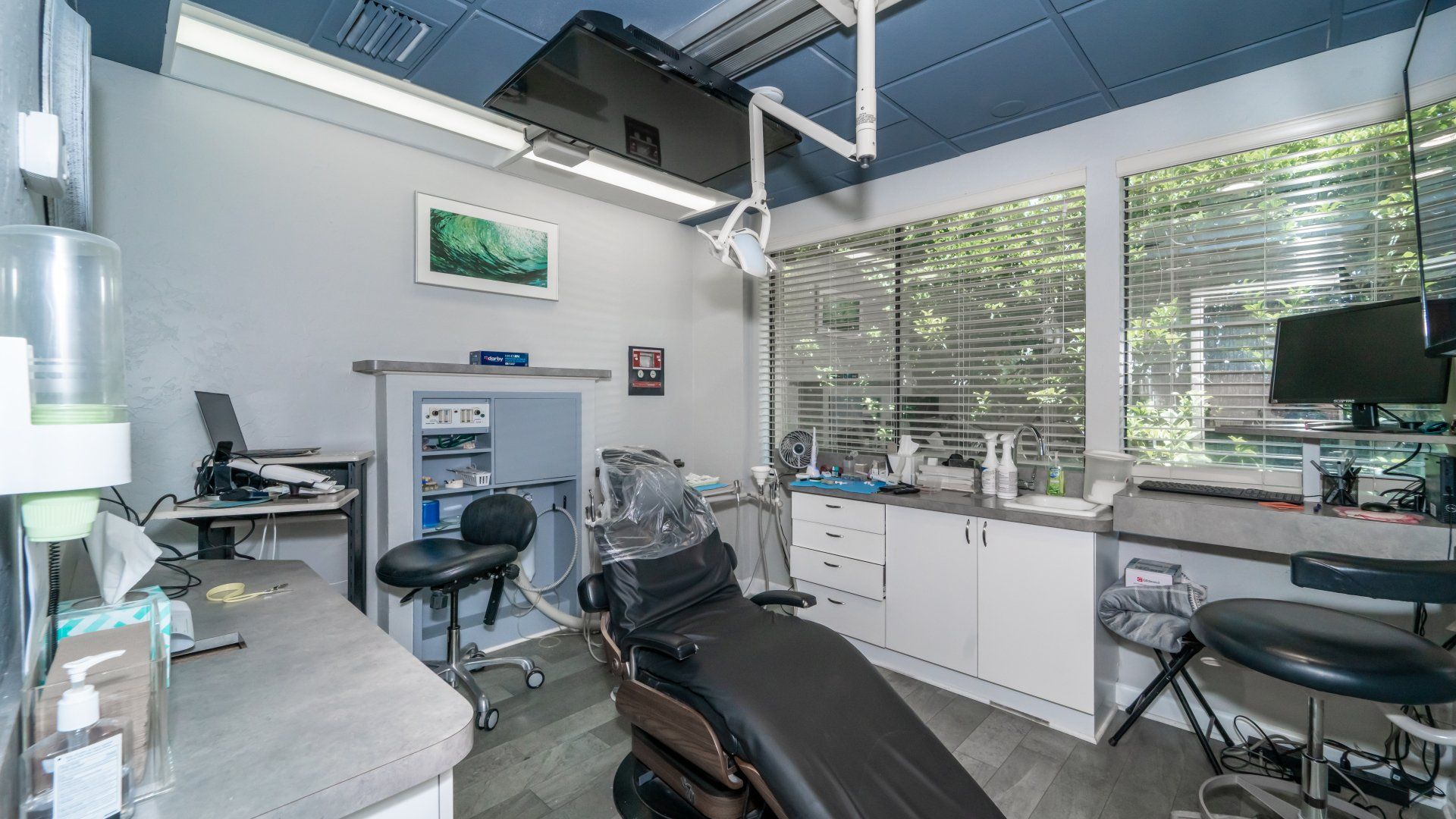 A dental office with a dental chair and a computer.