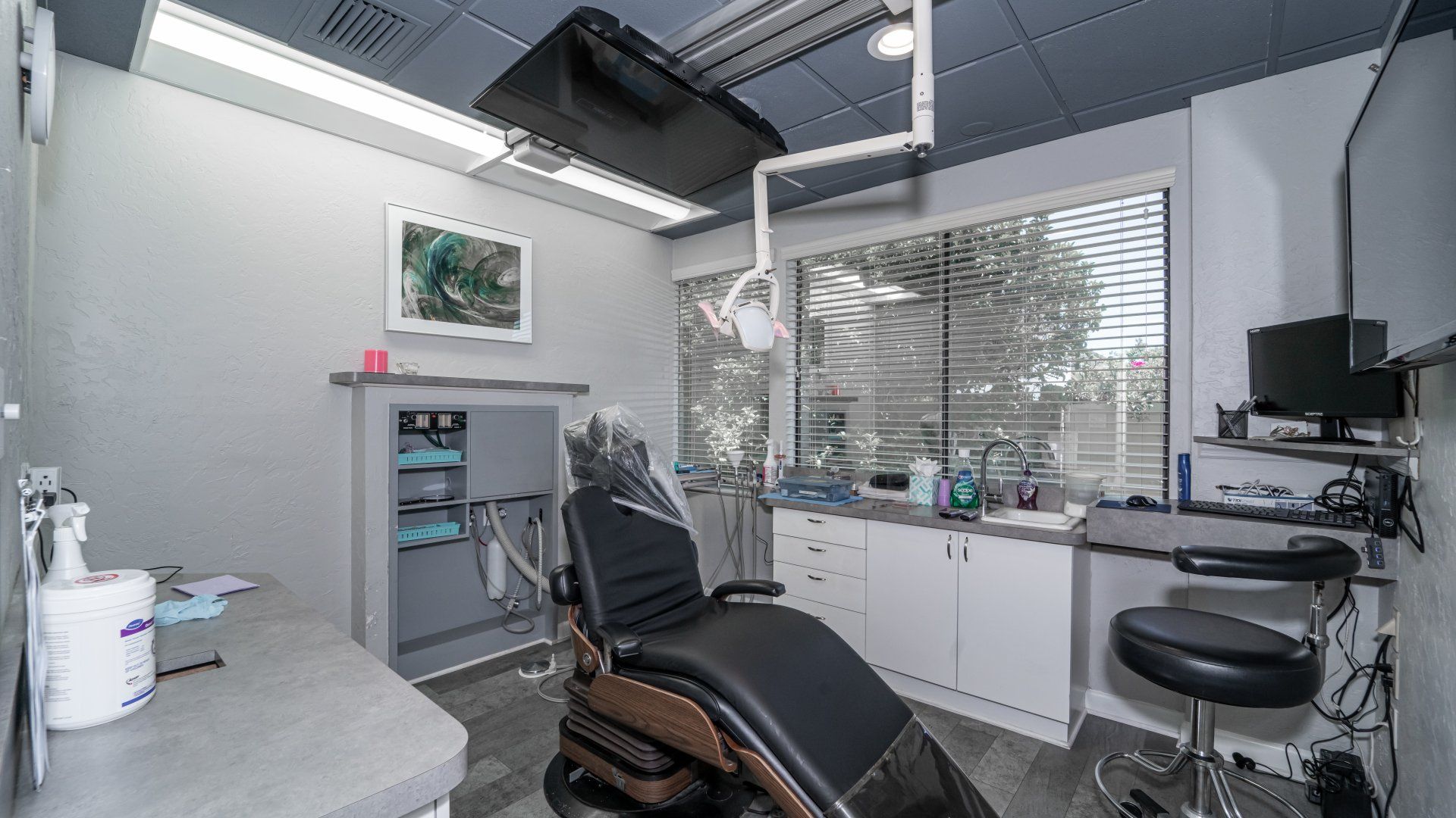 A dental office with a dental chair and a desk.