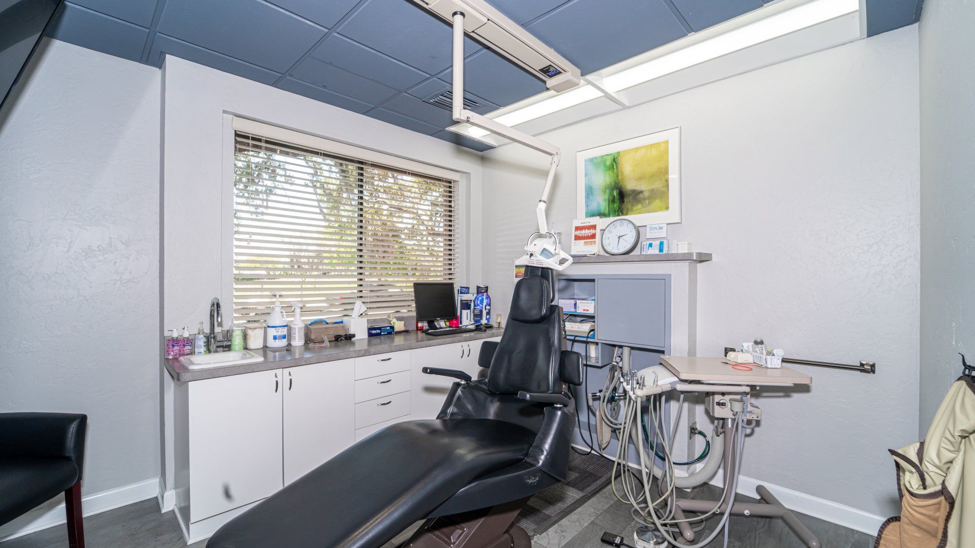 A dental office with a dental chair and a table.
