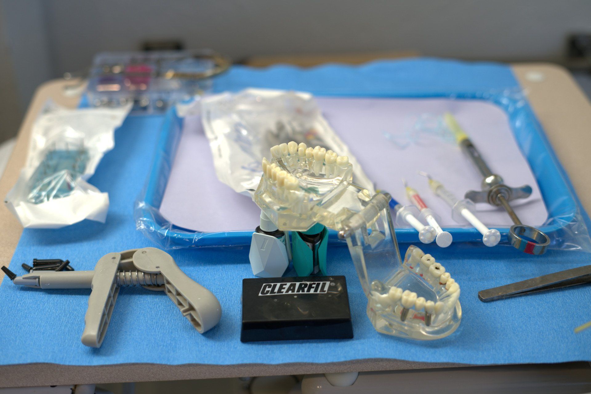 A table with dental instruments and a model of teeth on it