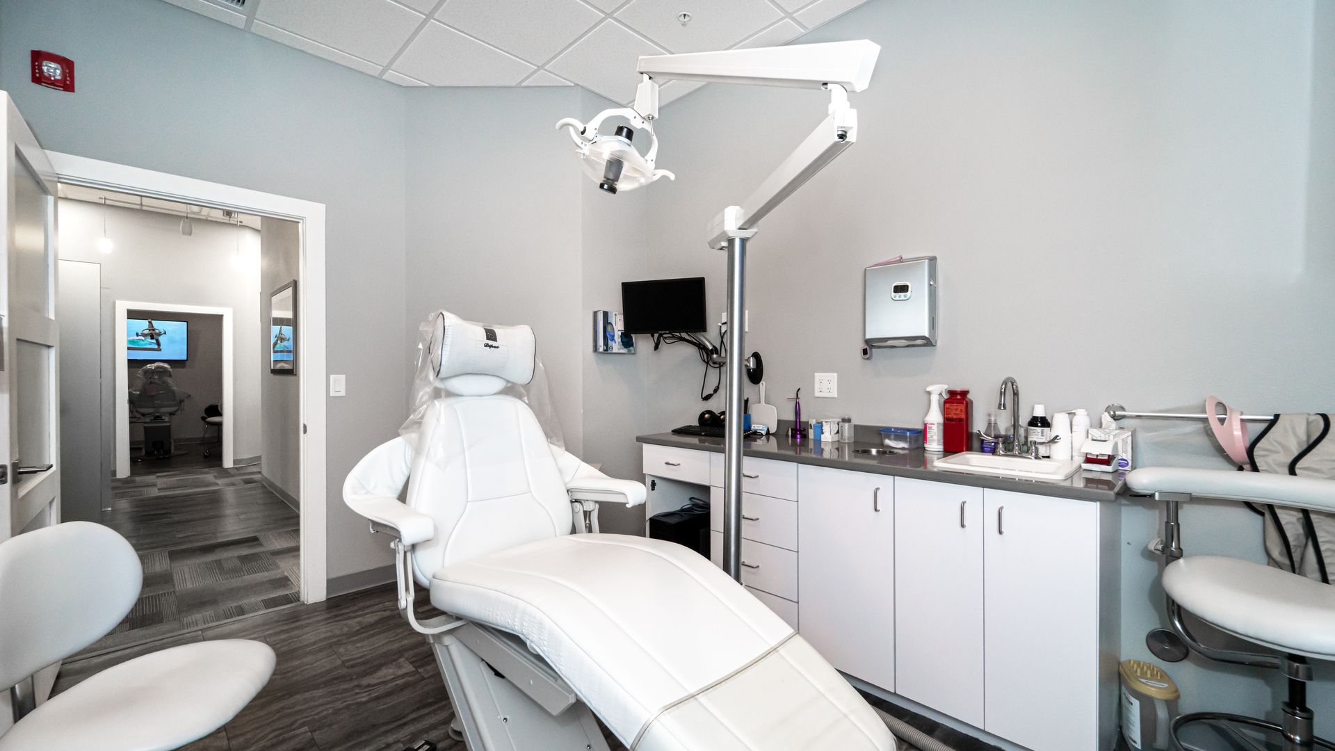 A dental office with a dental chair and a sink.
