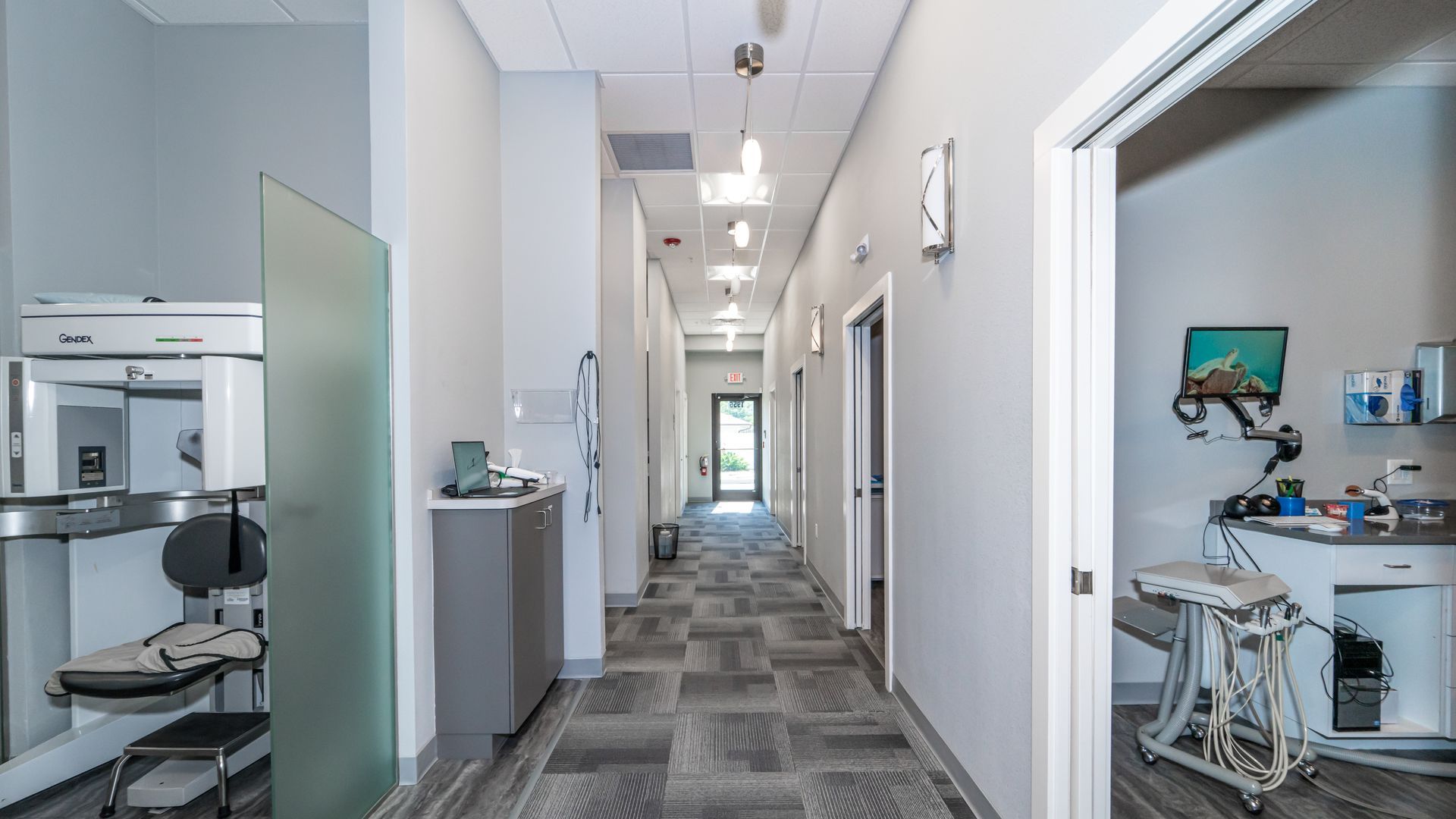 A long hallway in a dental office leading to a dental office.