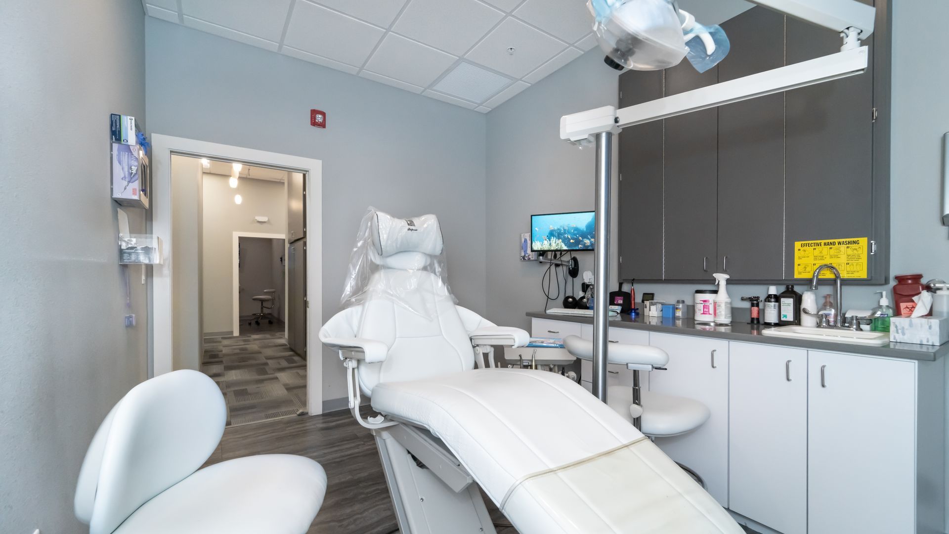 A dental office with a dental chair and a sink.