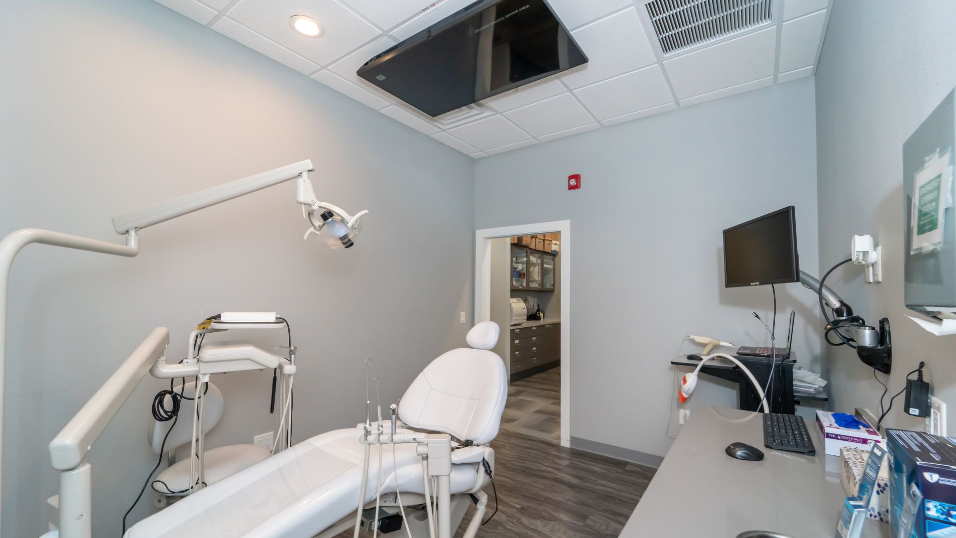 A dental office with a dental chair and a desk.