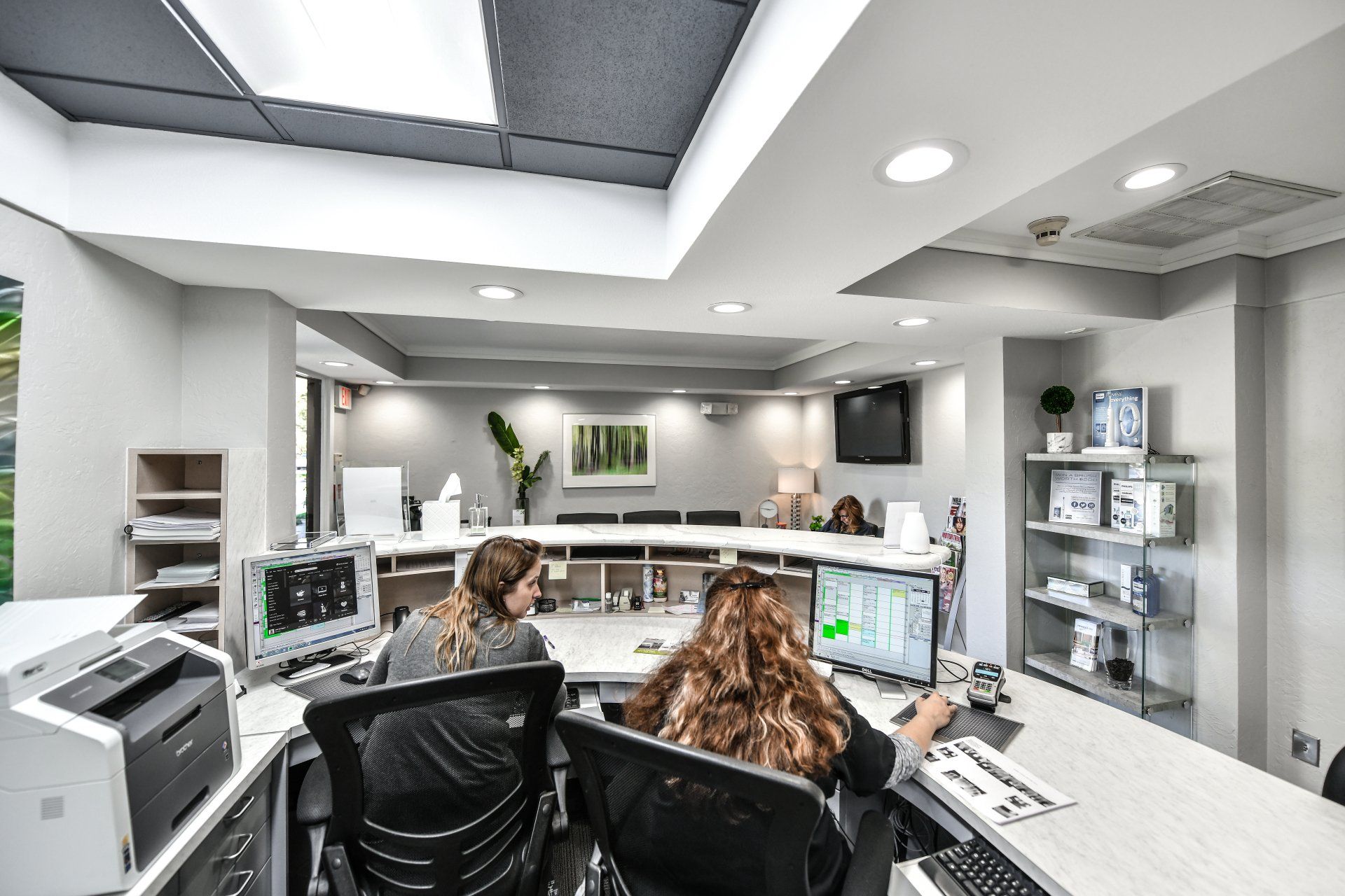 A group of people are sitting at a desk in an office.