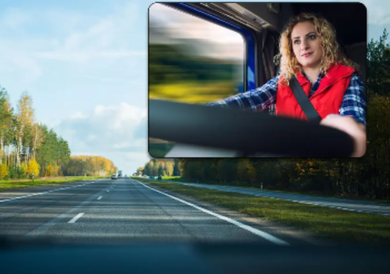 A woman is driving a truck down a highway.