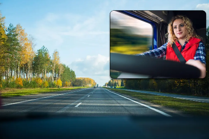 A woman is driving a truck down a highway.