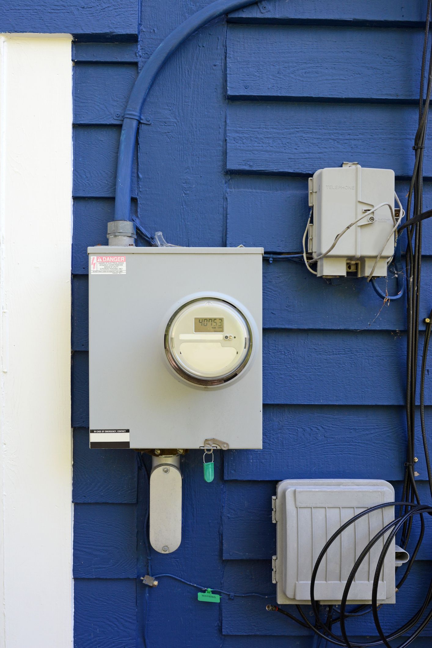A blue house has a meter on the side of it