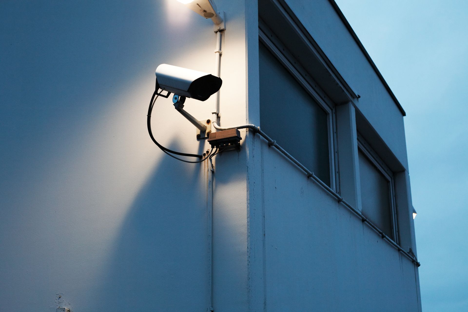 A security camera is mounted on the side of a building.