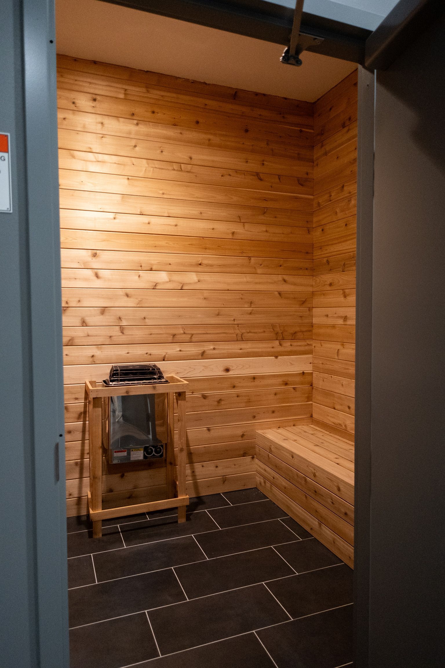 A locker room with lots of white lockers and benches.