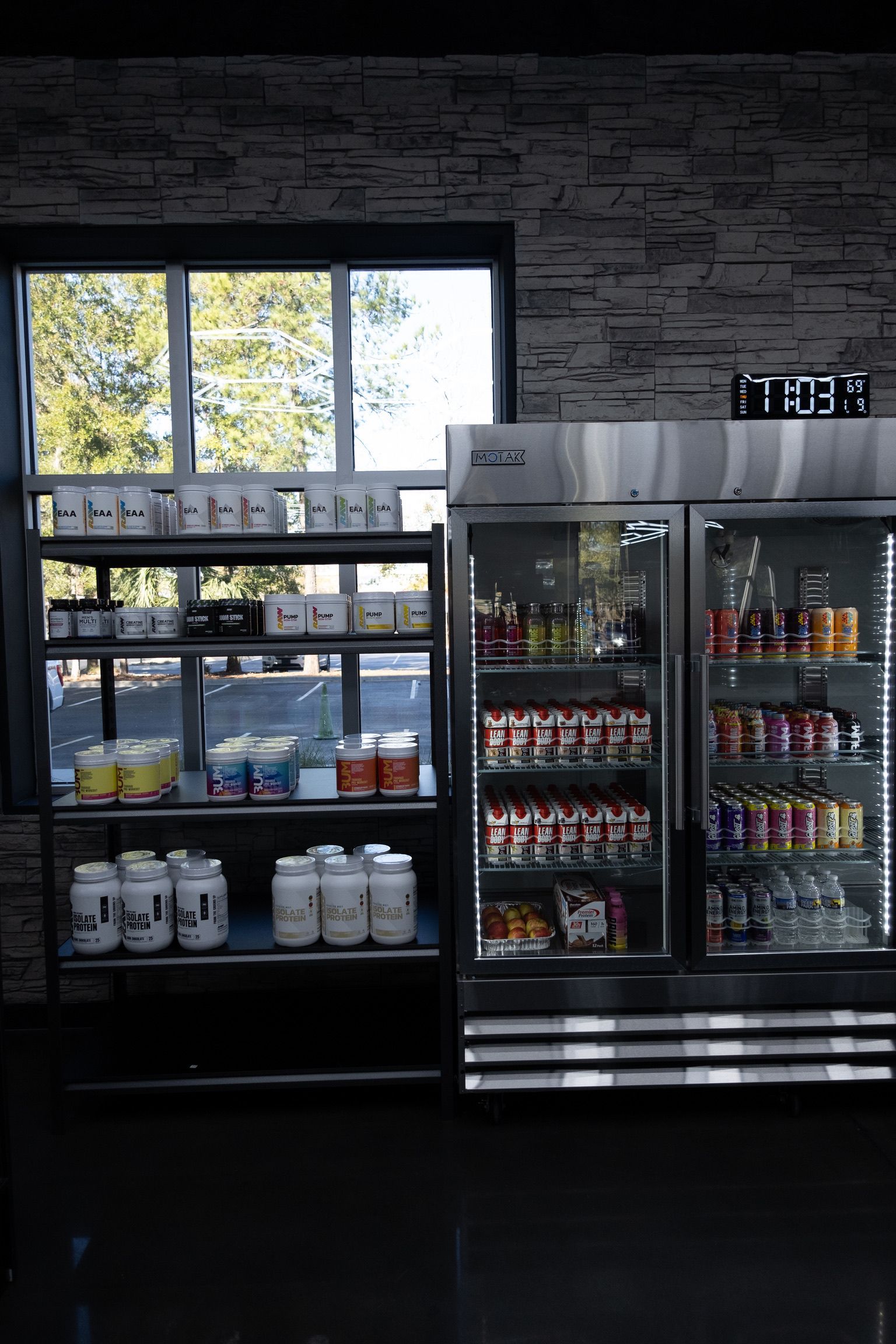 A woman is holding a jar of protein powder in a store.