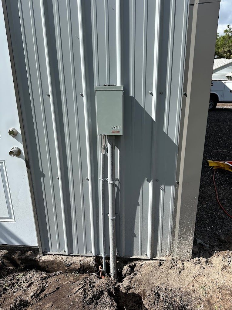 There is a box on the side of a building next to a door.