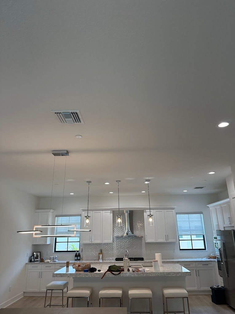A kitchen with white cabinets and a large island in the middle of the room.