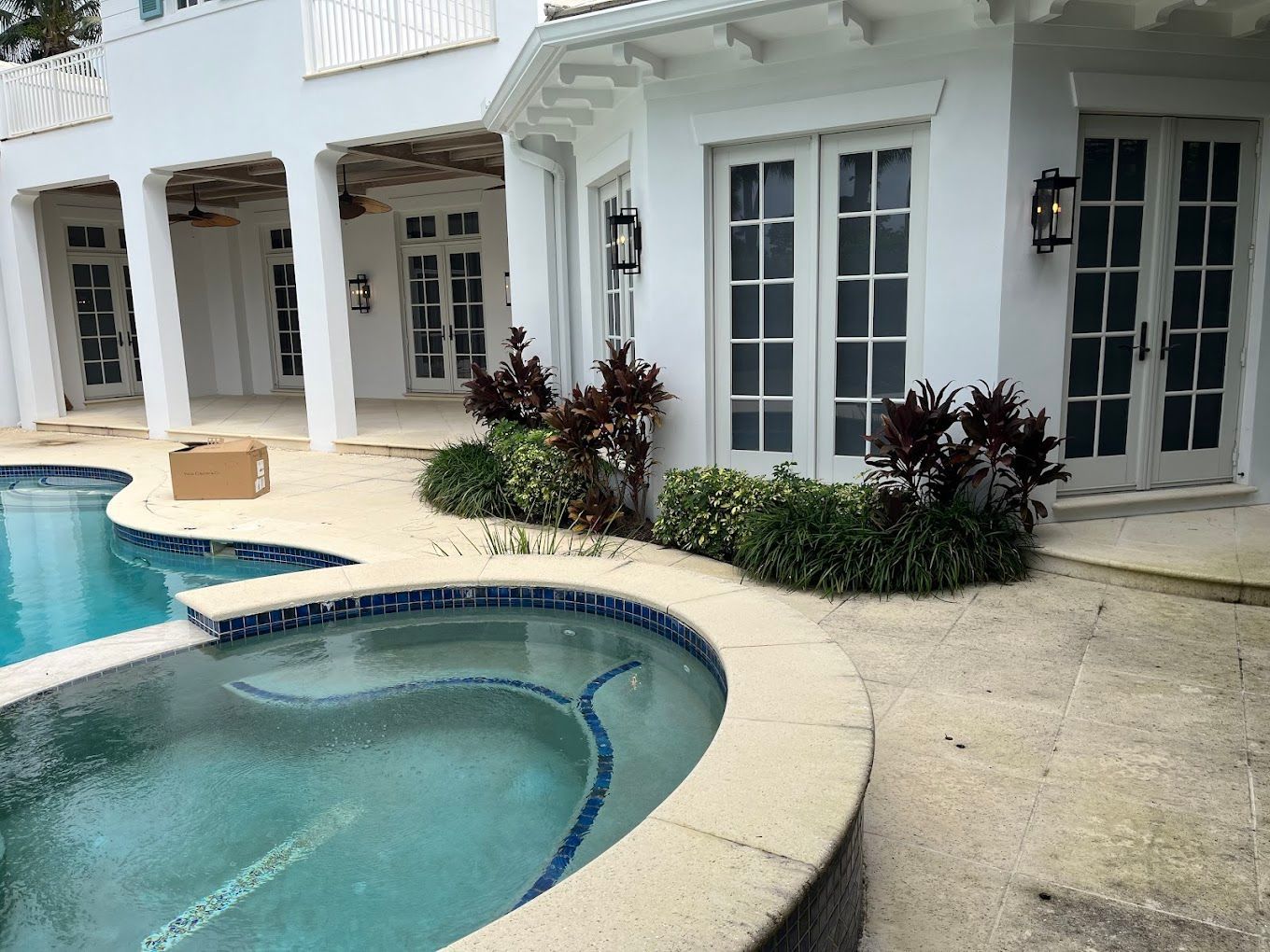 A large white house with a swimming pool in front of it