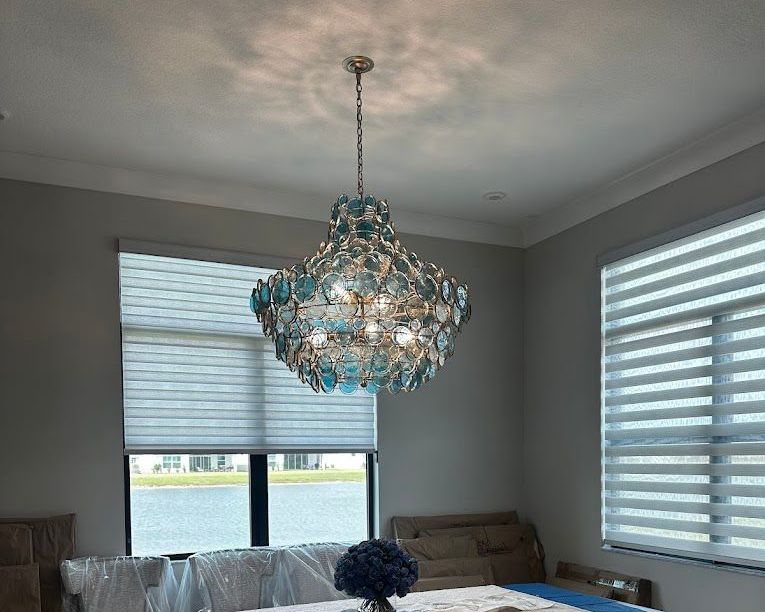A dining room with a table and a chandelier hanging from the ceiling.