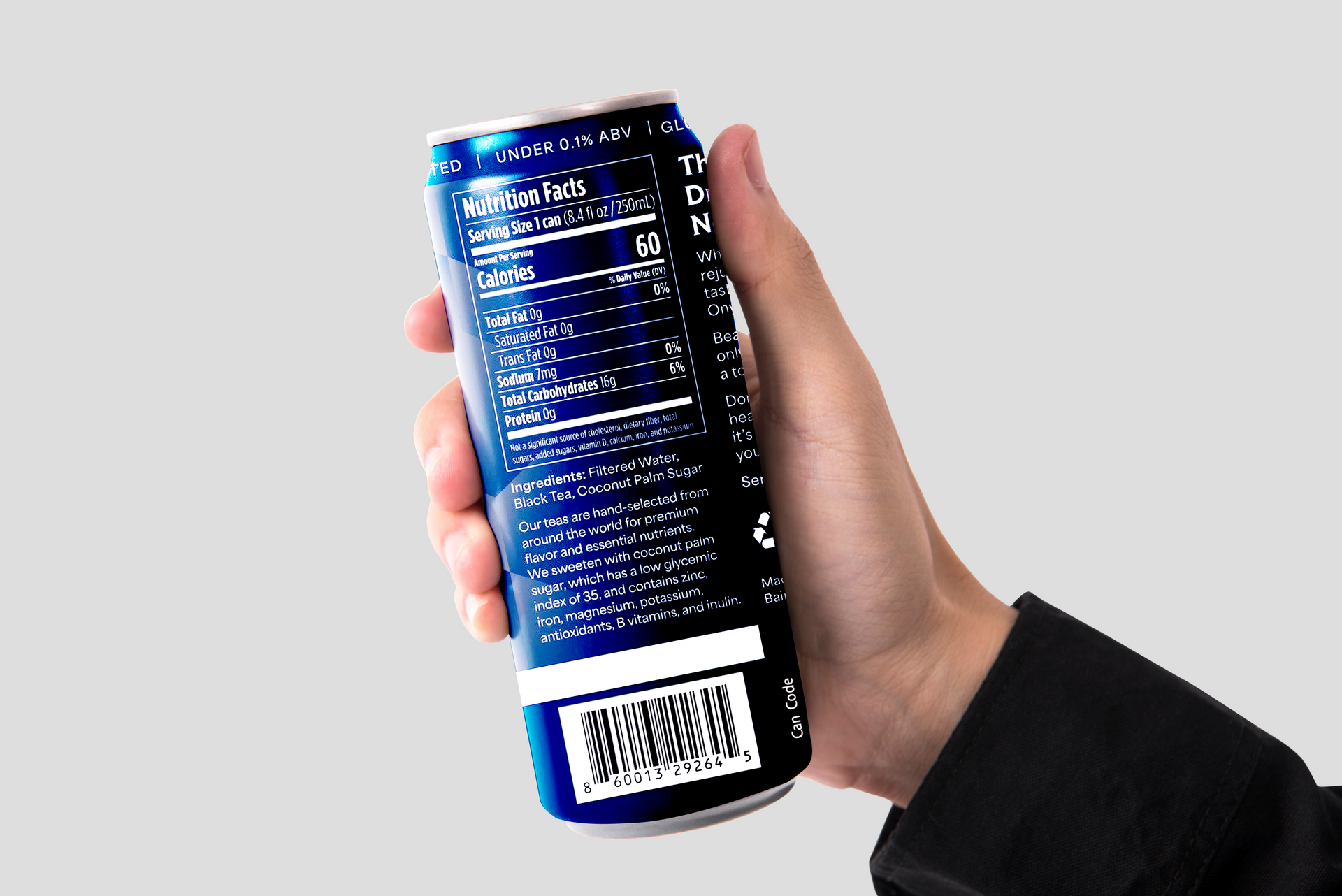 A hand holds a dark blue energy drink can, showing the nutrition facts label and barcode against a light gray background.