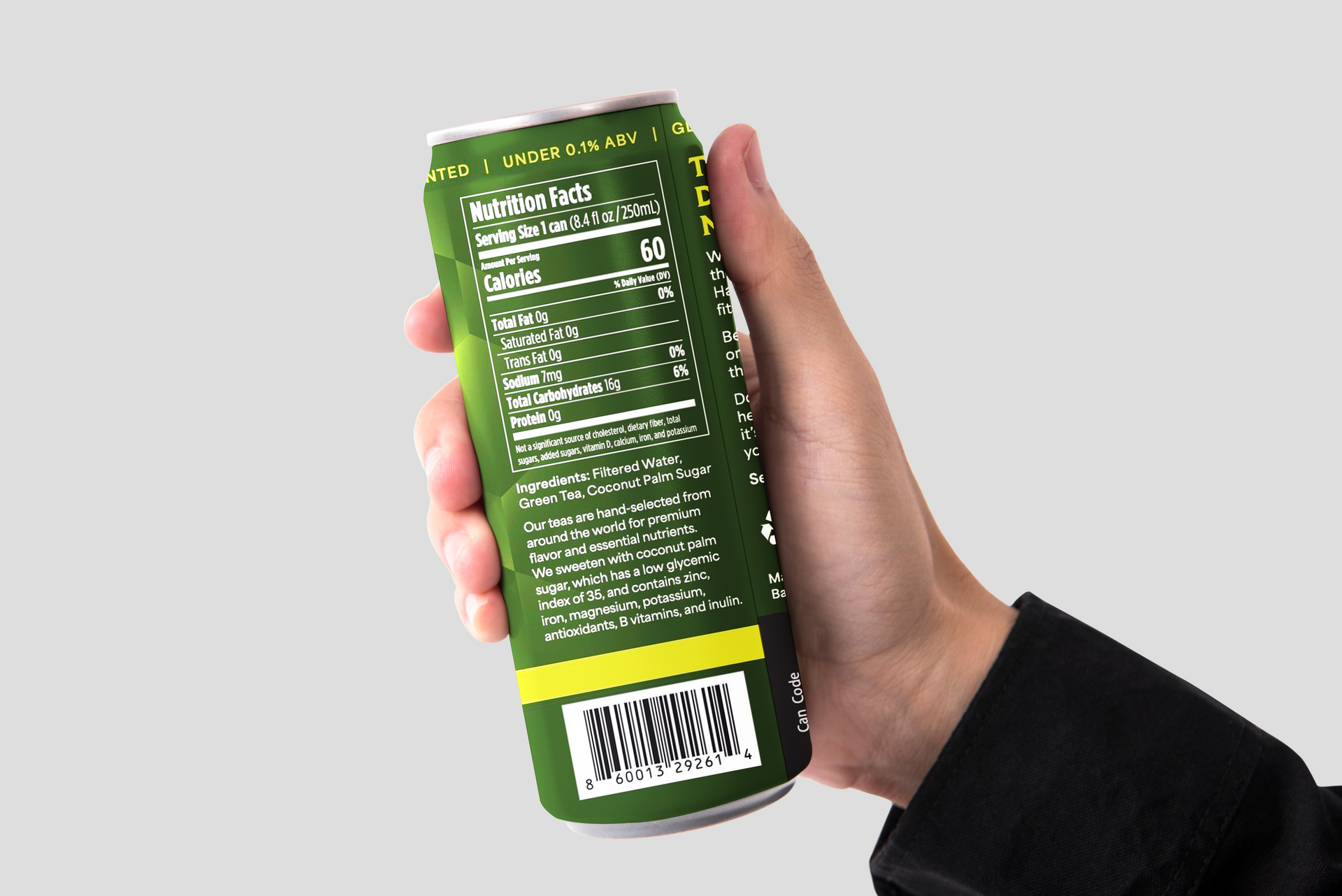 A hand holds a green aluminum can, displaying the nutritional information label and a barcode on a plain gray background.