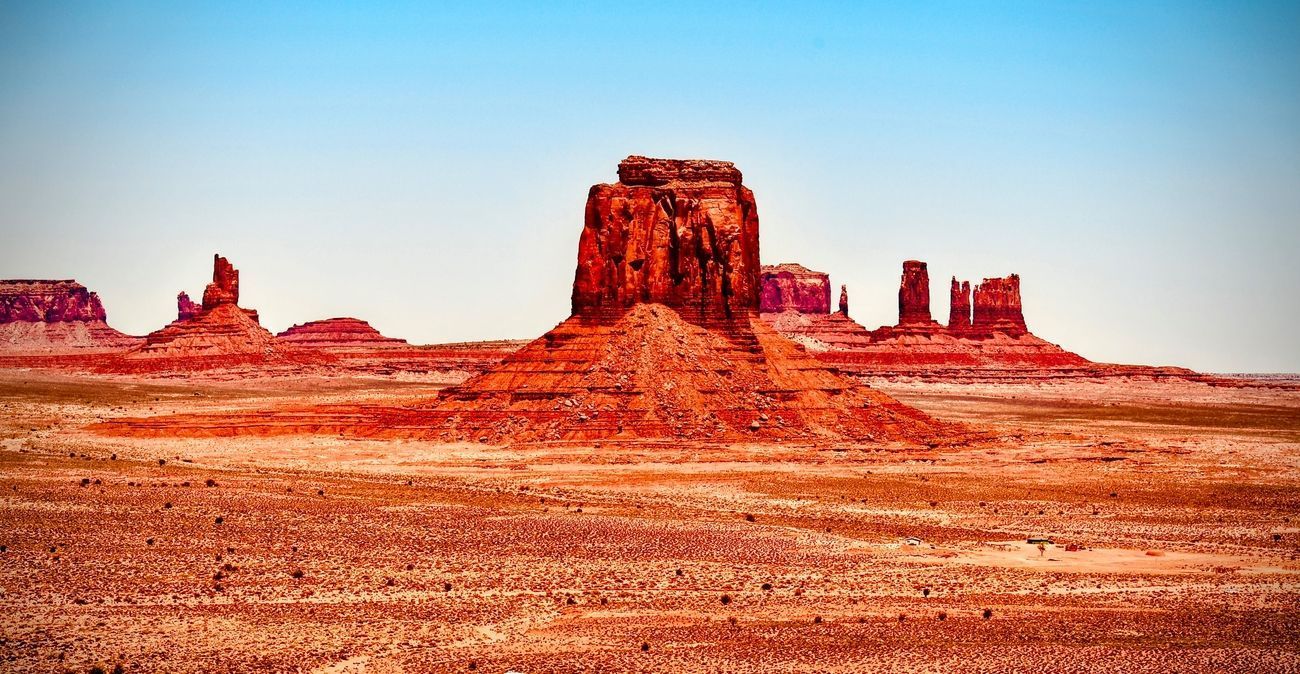Red rock formations in the desert under a blue sky, similar to Monument Valley.