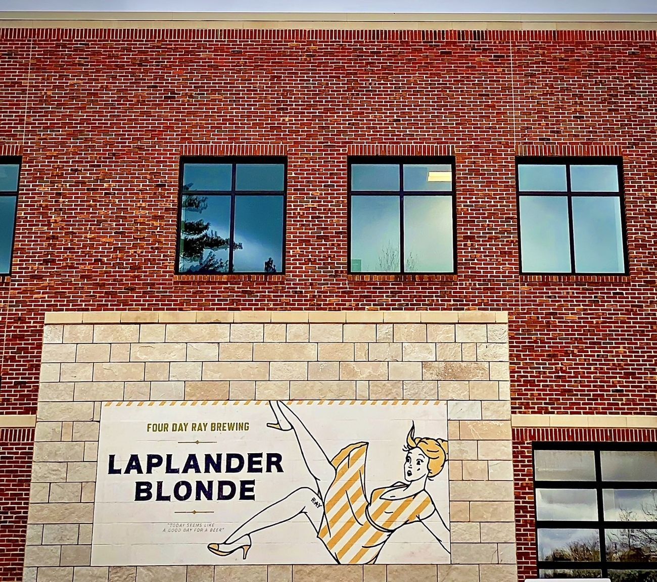 Brick building with windows. Sign: