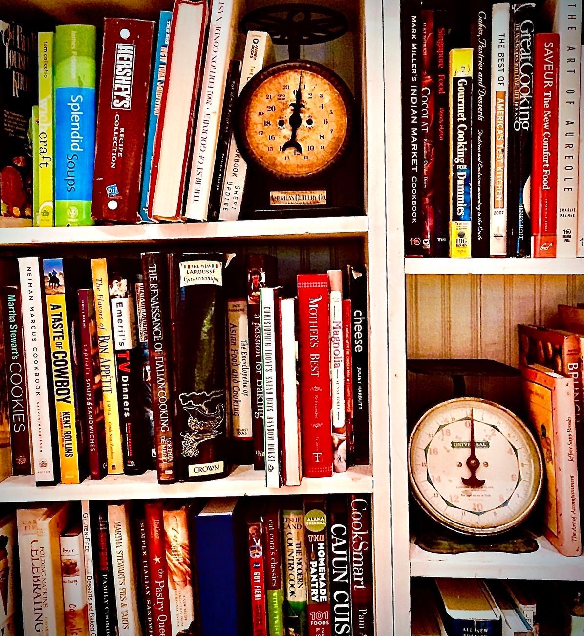 Bookshelves filled with cookbooks, including vintage scale.