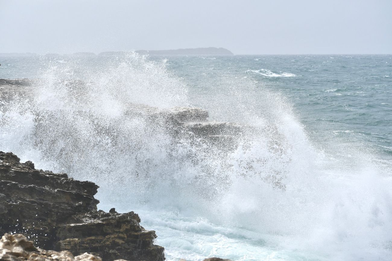 Ocean waves crashing against rocky shoreline.