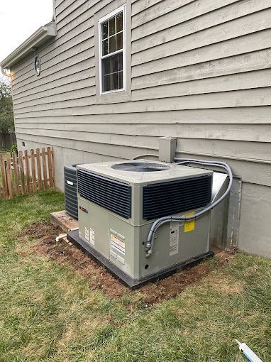 An air conditioner is sitting on the side of a house.