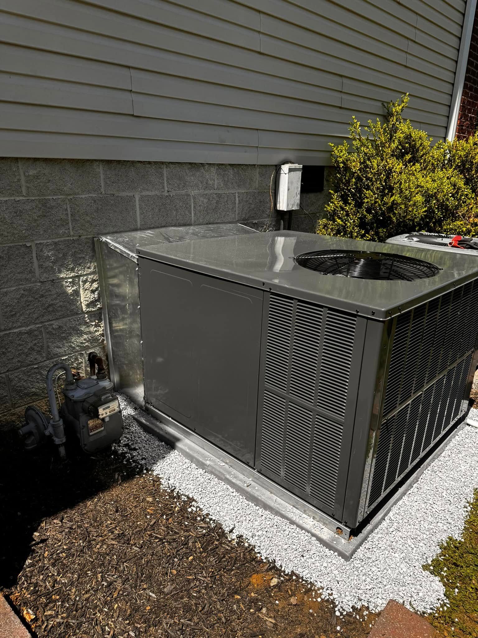 An air conditioner is sitting on the side of a house.