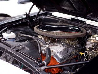 A close up of a car engine with the hood open