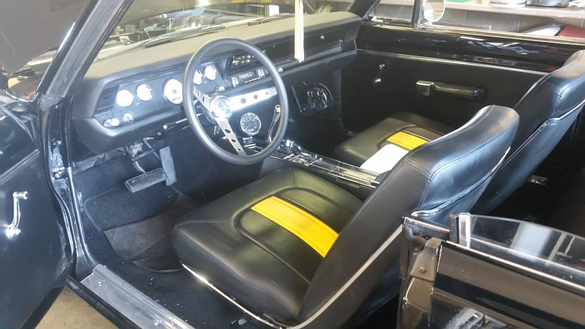 The interior of a black car with yellow stripes on the seats