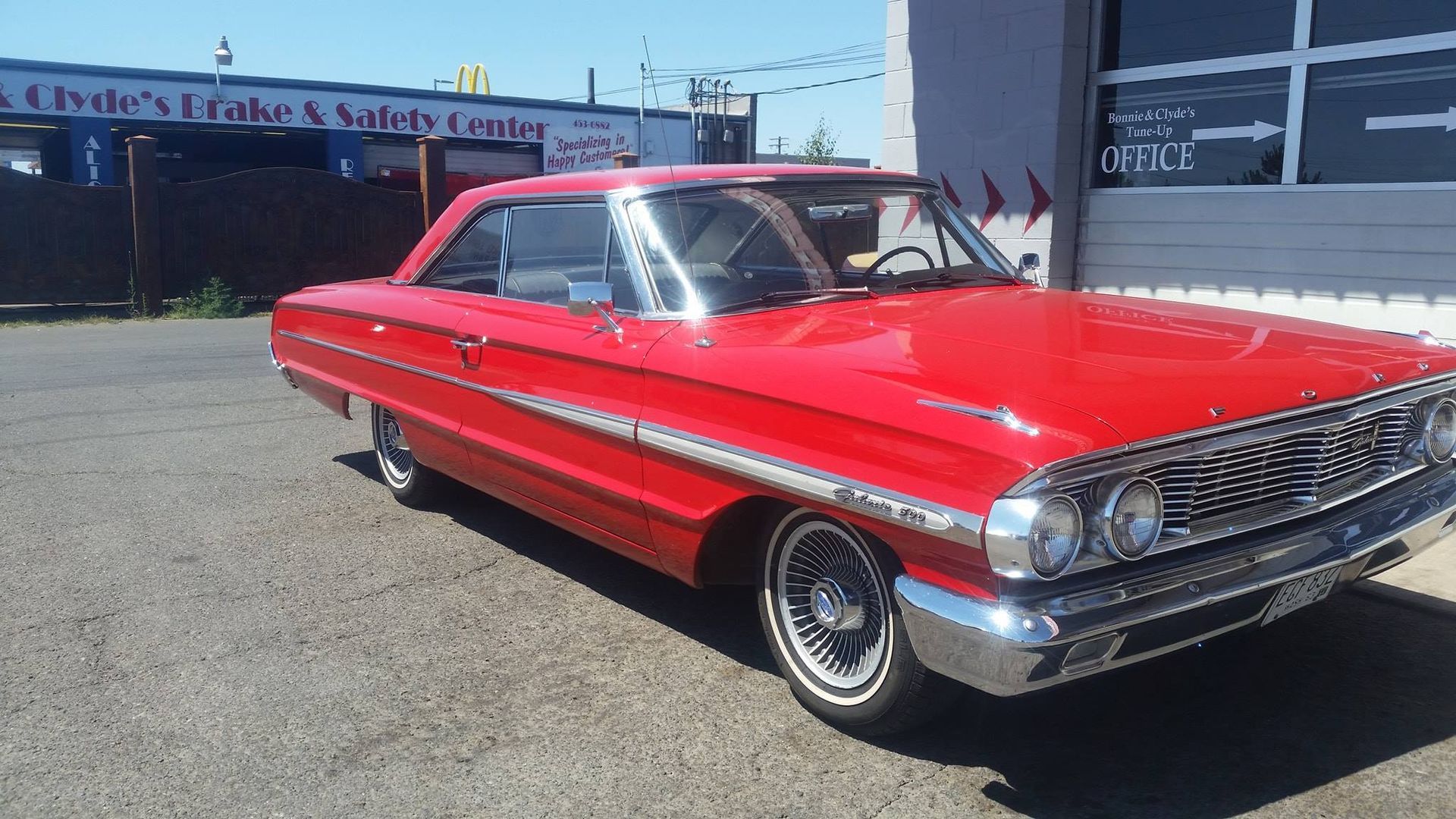A red car is parked in front of a building.