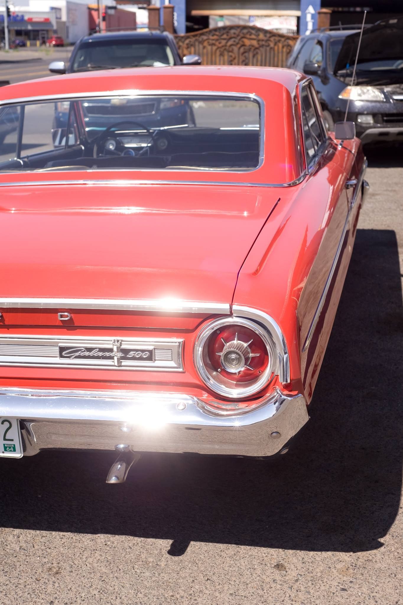 A red car is parked on the side of the road