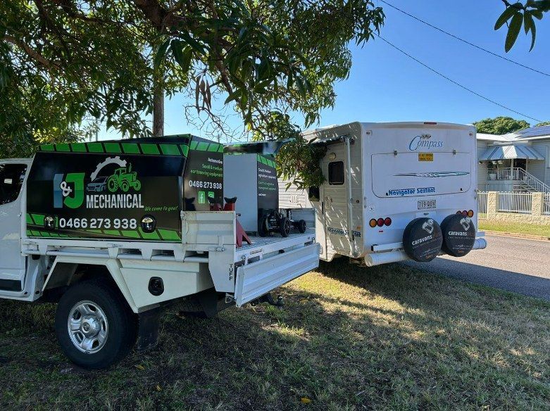 A White Truck With Branding is Parked Next to a Camper — I & J Mechanical in Deeragun, QLD