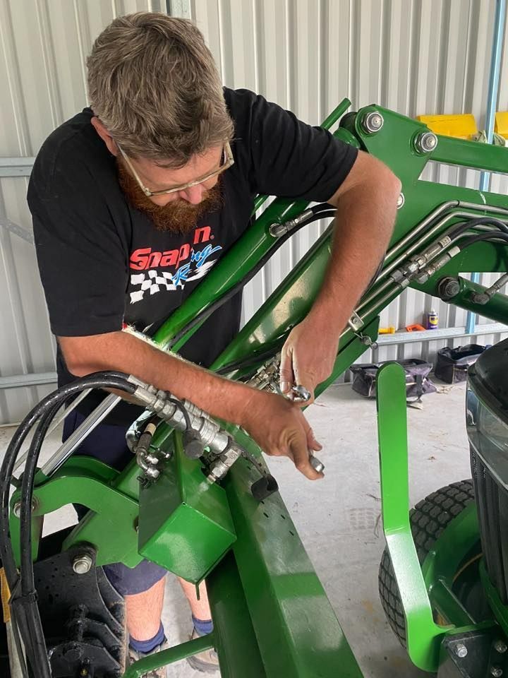 A Man Wearing Glasses Works on a Agree Farm Equipment — I & J Mechanical in Deeragun, QLD