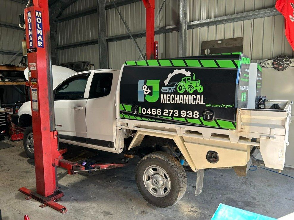 White Pickup Truck With Logo on the Side in a Garage — I & J Mechanical in Deeragun, QLD