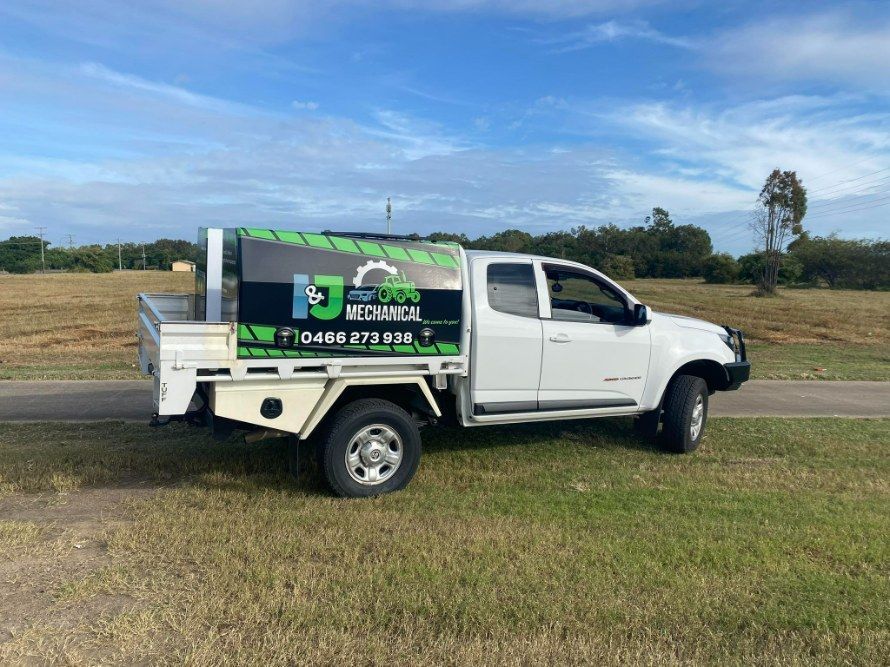 White Truck With a Mechanical Company Logo Parked on Grass — I & J Mechanical in Deeragun, QLD